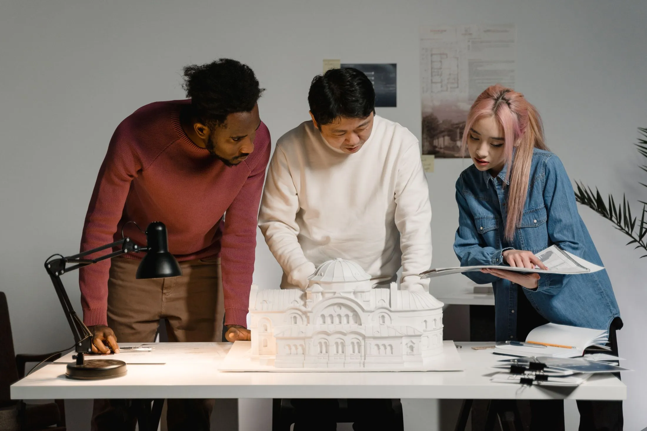 Three architects looking over a scale model of a building