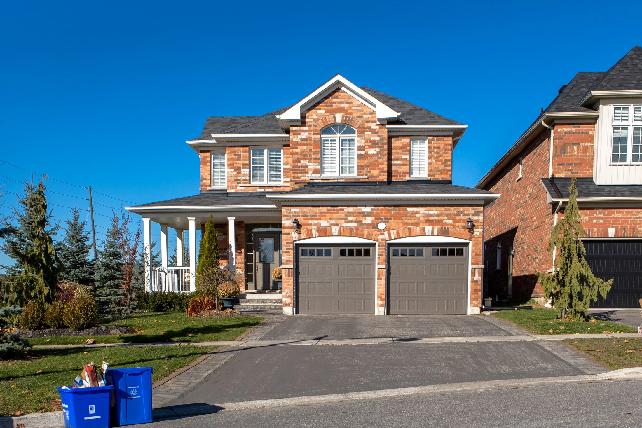 A brick two-storey home with a covered porch in an established Aurora neighbourhood