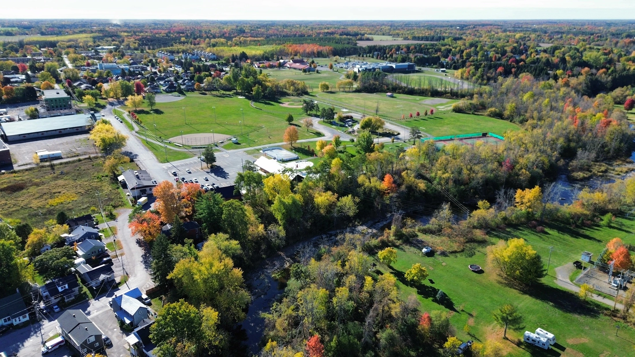 Aerial view of a town park and sports fields surrounded by autumn trees near Aurora
