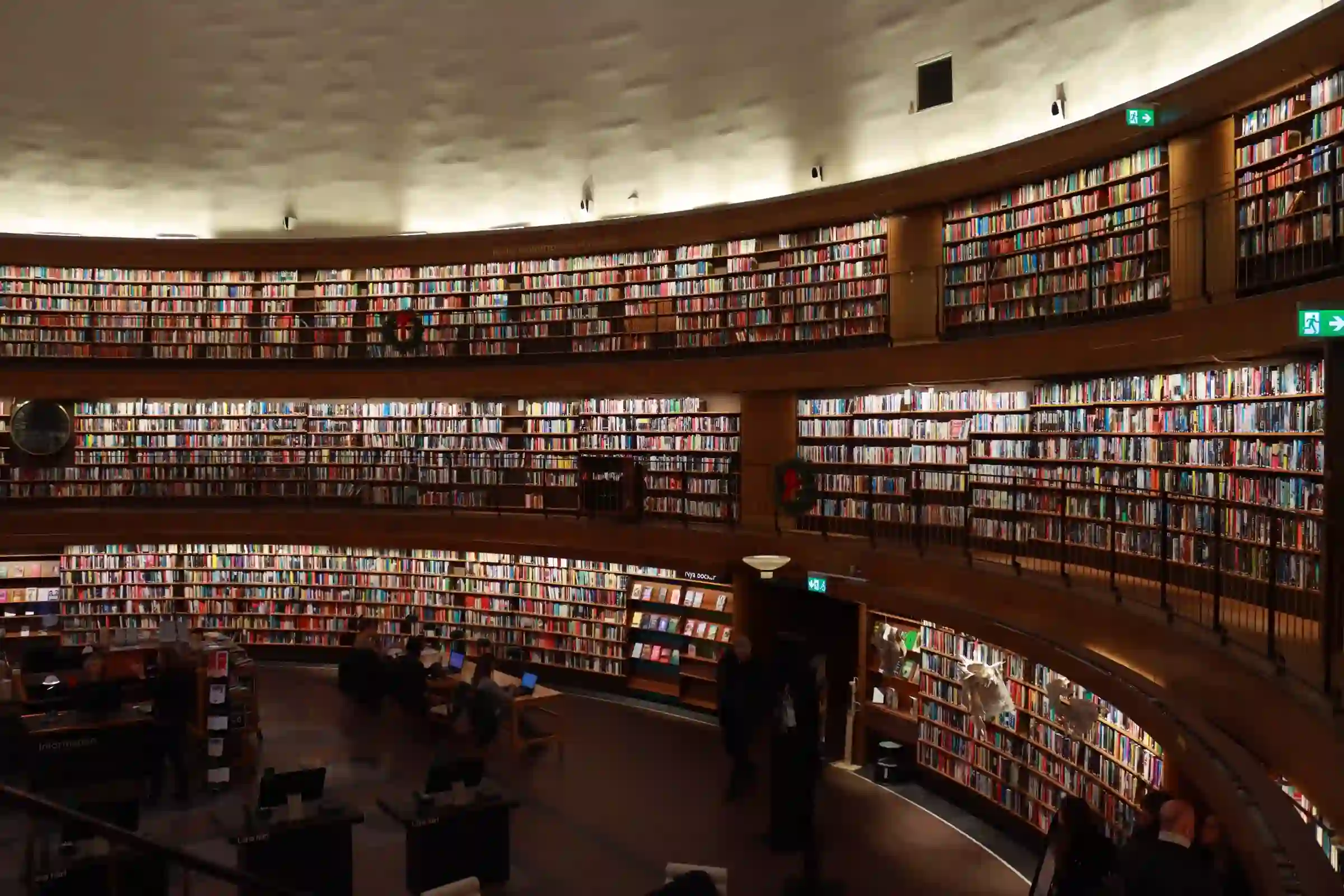 A dramatic, curved multi-level library lined with shelves