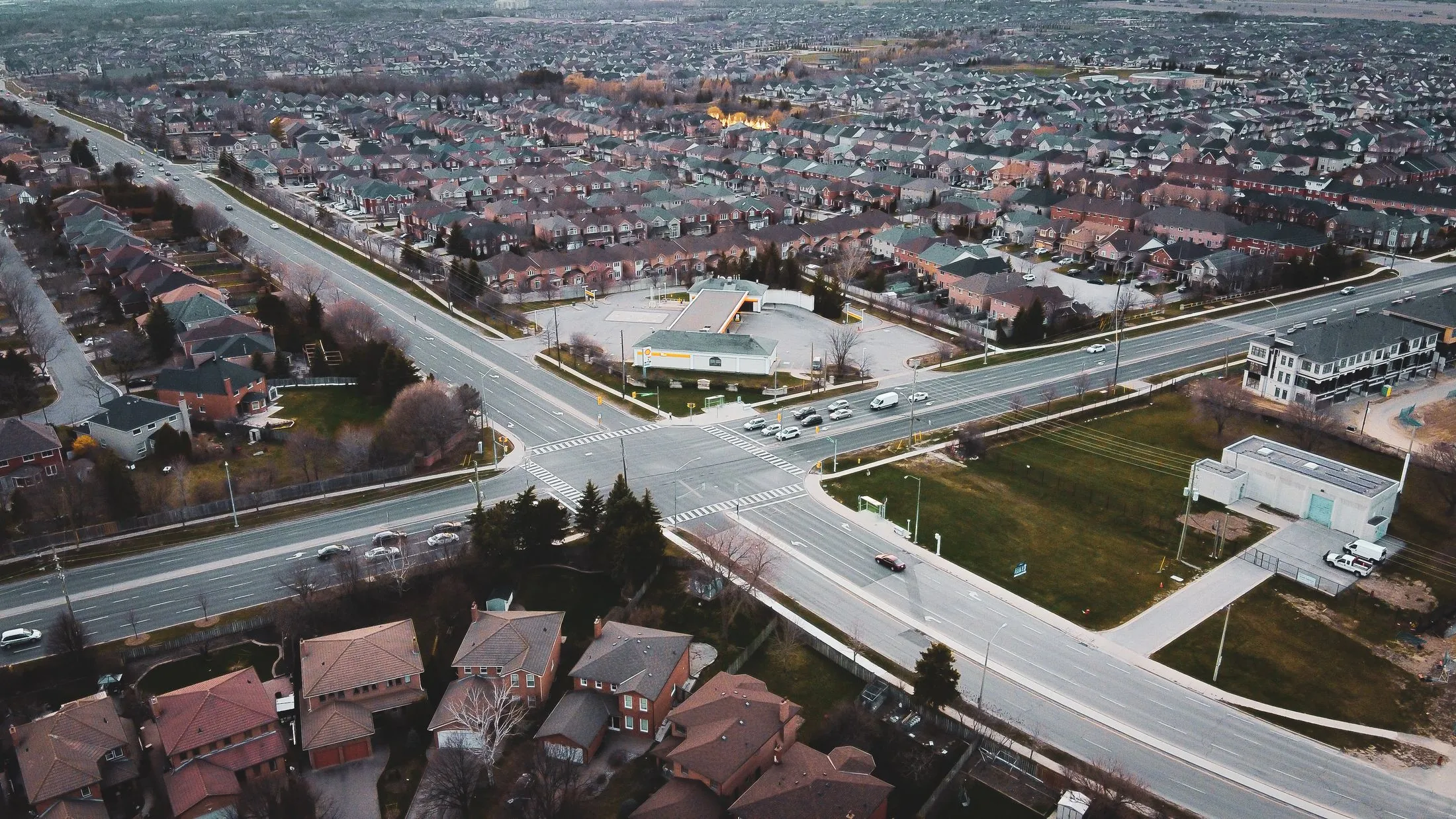 An aerial view of a suburban intersection lined with rows of homes