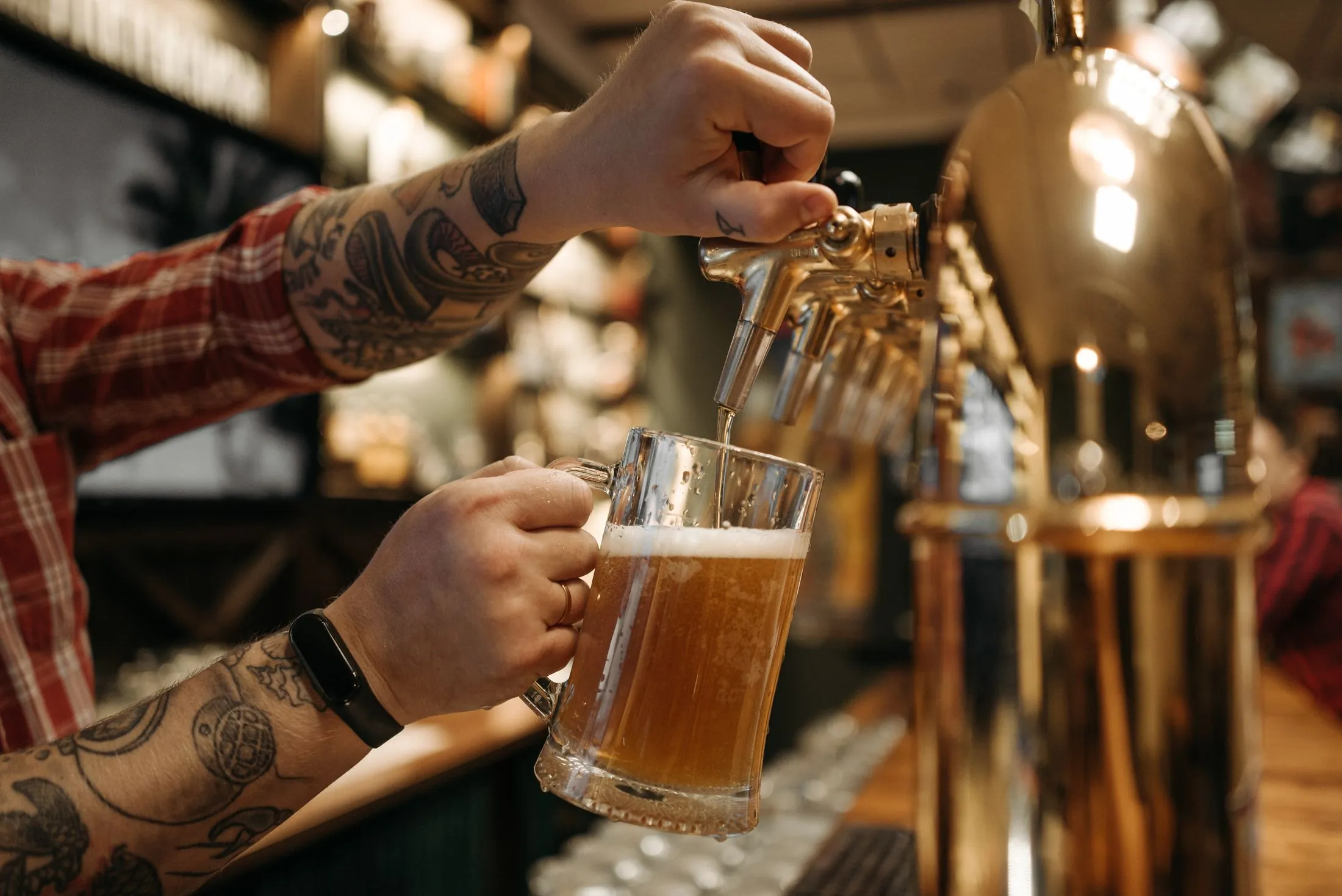 A bartender pouring a draft beer from the tap