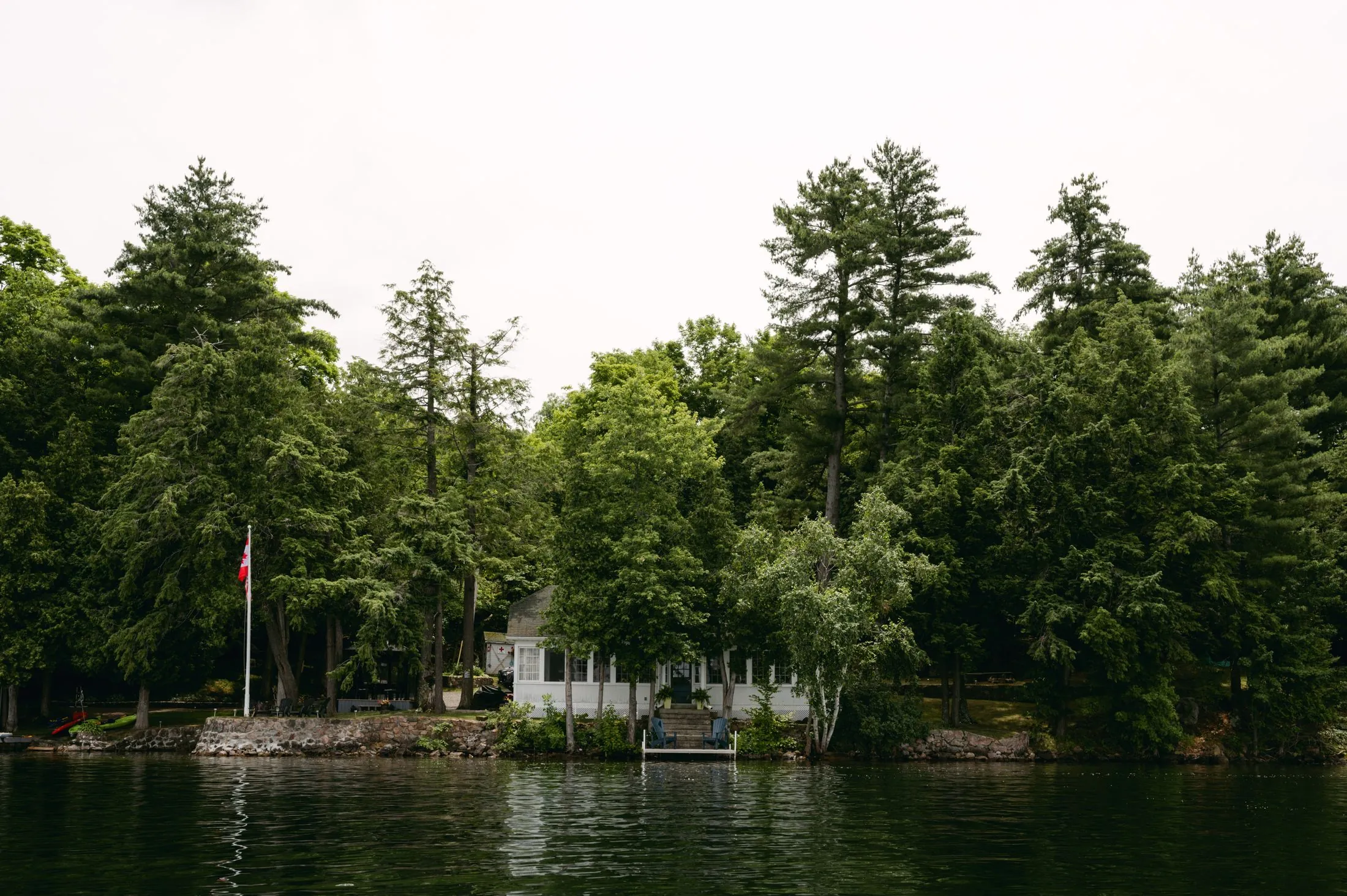 A waterfront cottage surrounded by forest on a summer day in Ontario