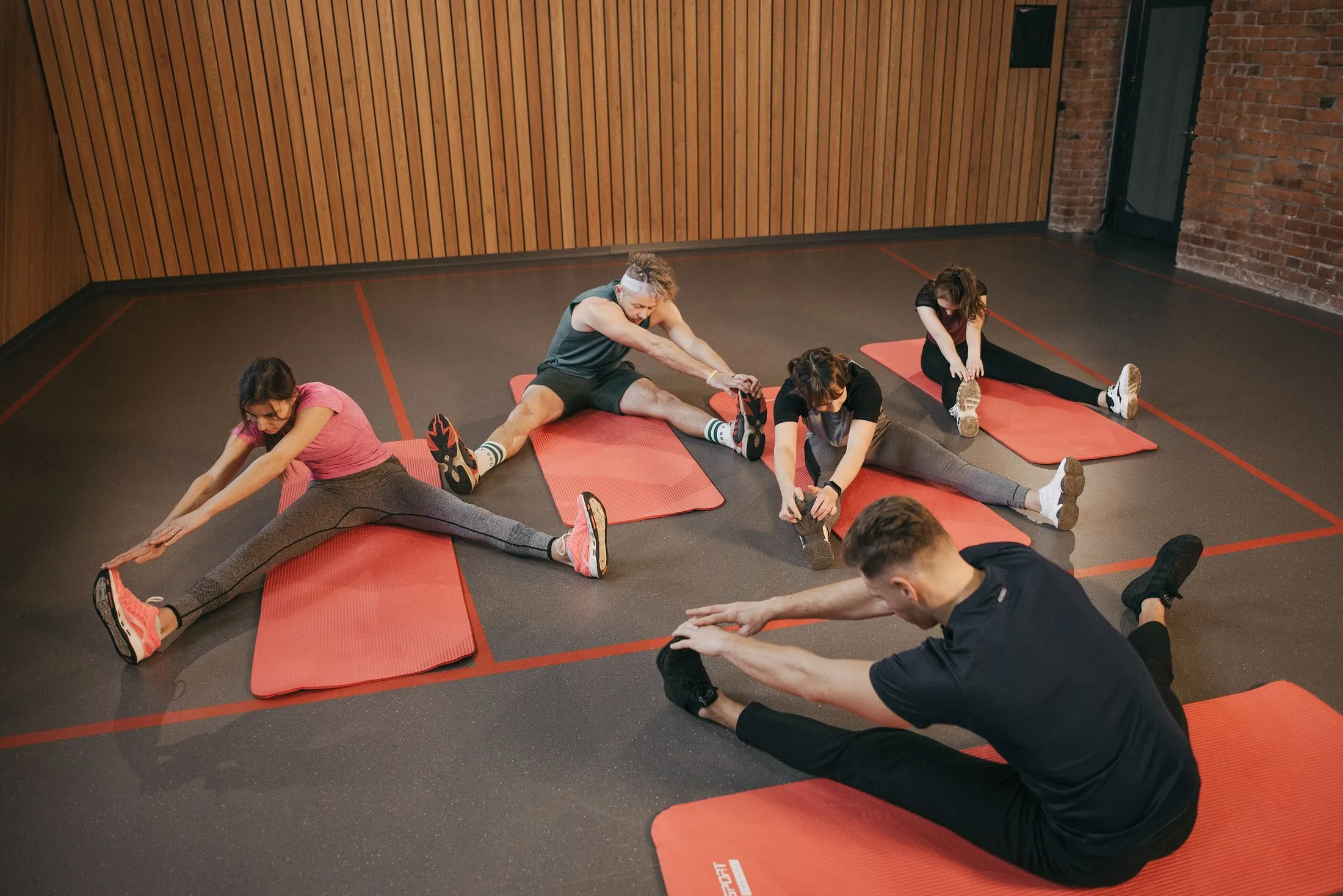 A group stretching on mats in a fitness studio