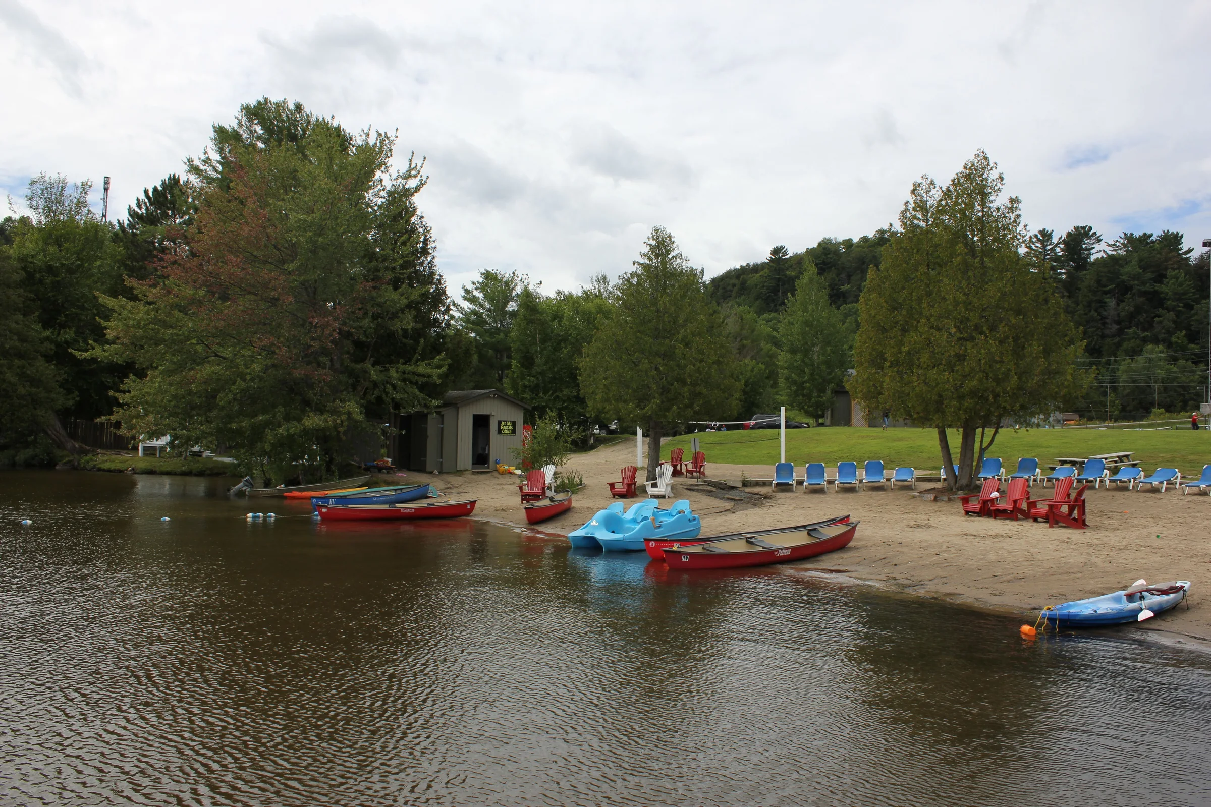 Canoes, kayaks and paddle boats lined up on a beach near Huntsville