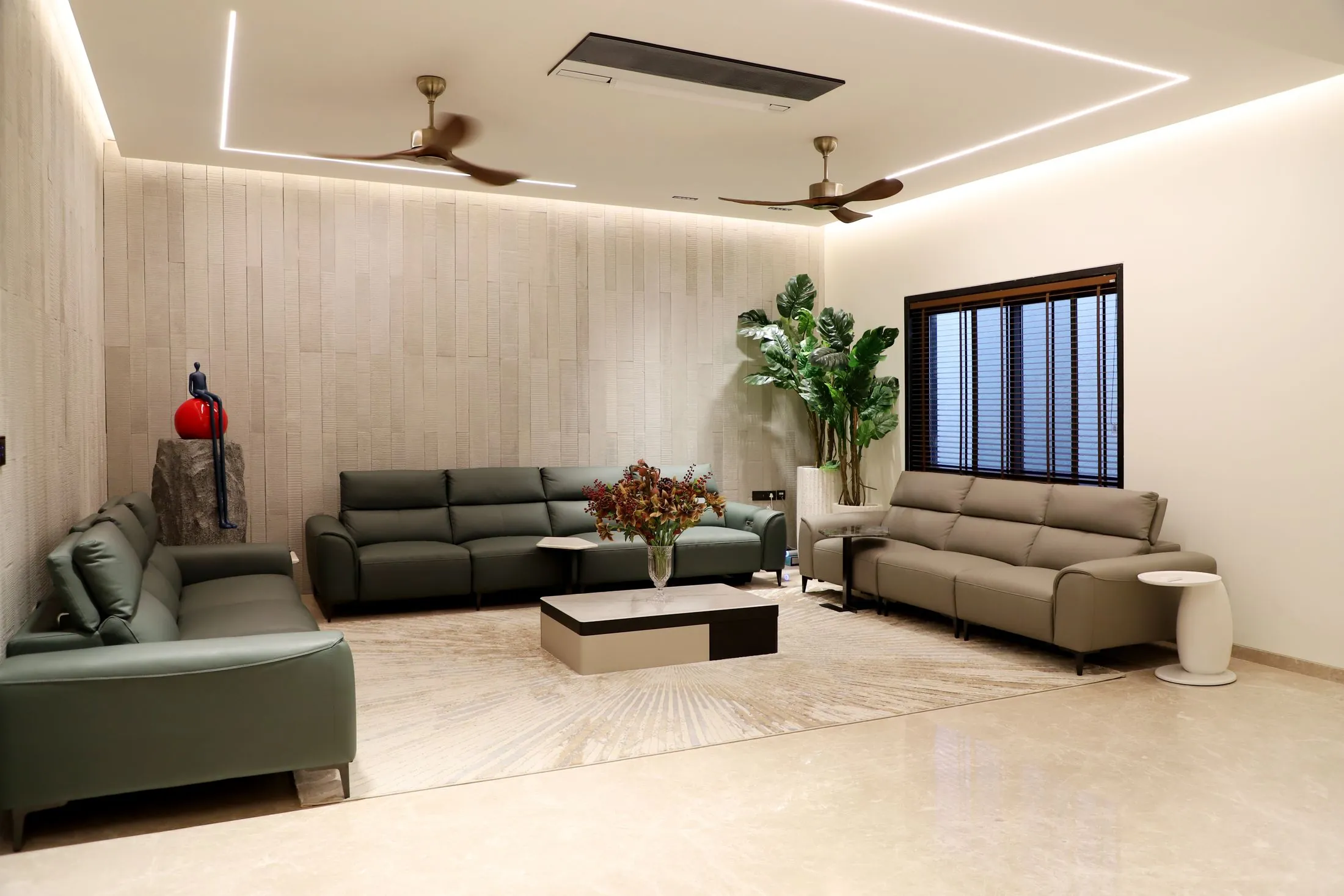 A bright living room with green sofas, warm lighting and indoor plants