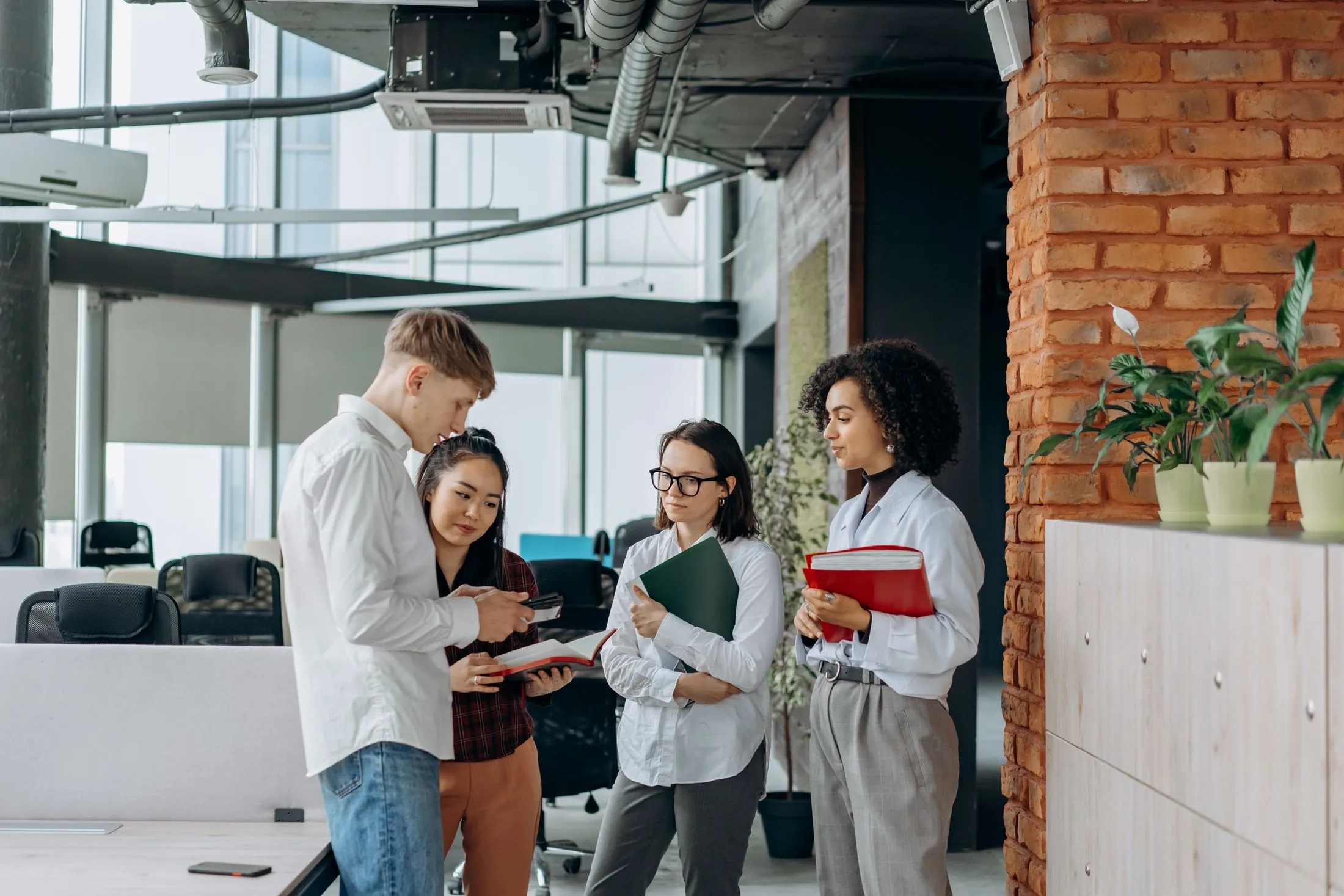 A team talking through documents in a bright, open office