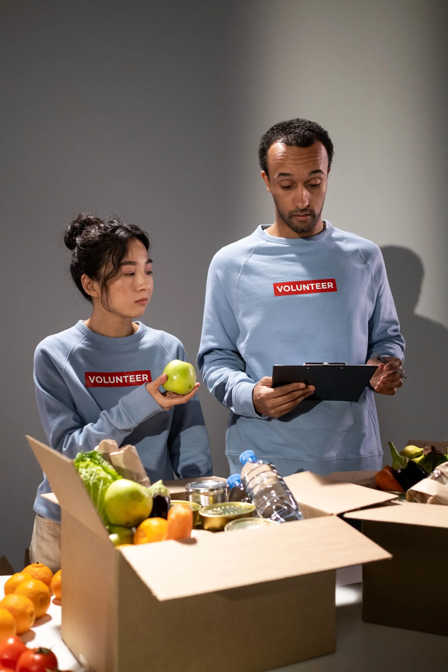 Volunteers sorting fresh produce into donation boxes