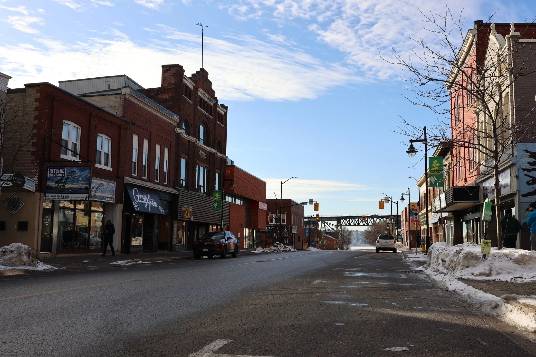 A small-town main street of brick storefronts on a clear winter day