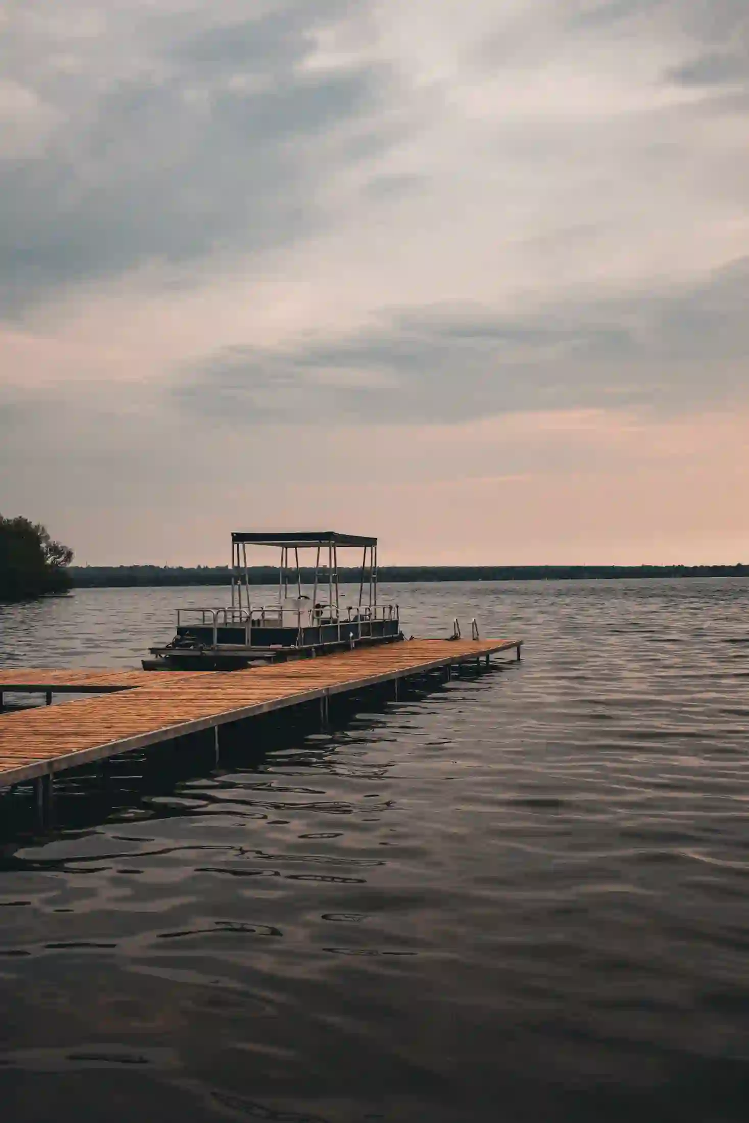 A pontoon boat docked at sunset near Orillia