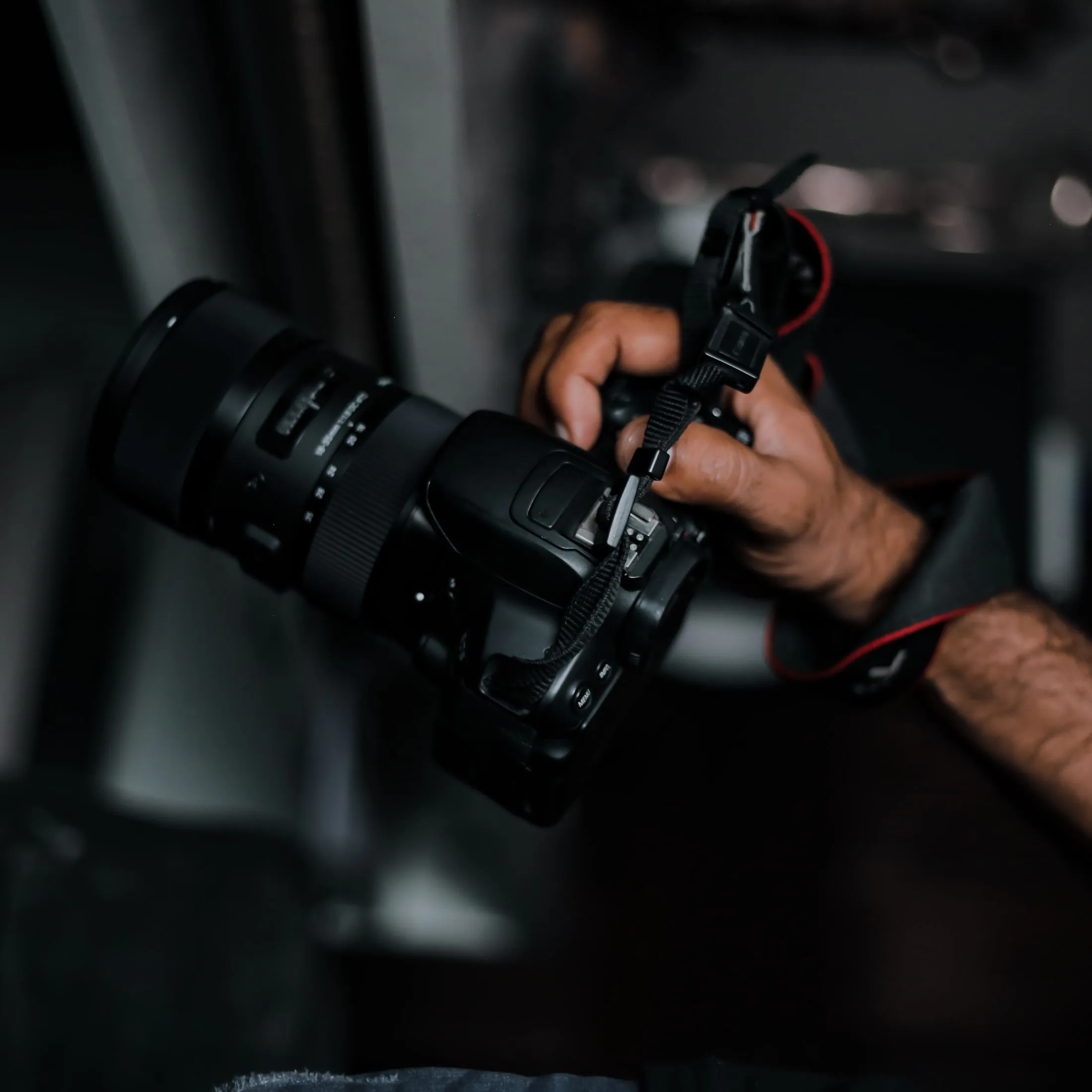 A photographer's hand gripping a DSLR camera