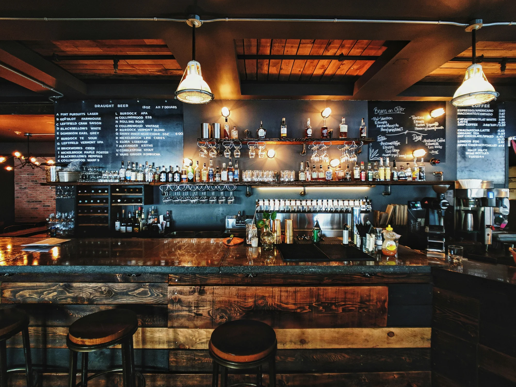 Backlit bar shelves lined with bottles in a dim, moody restaurant