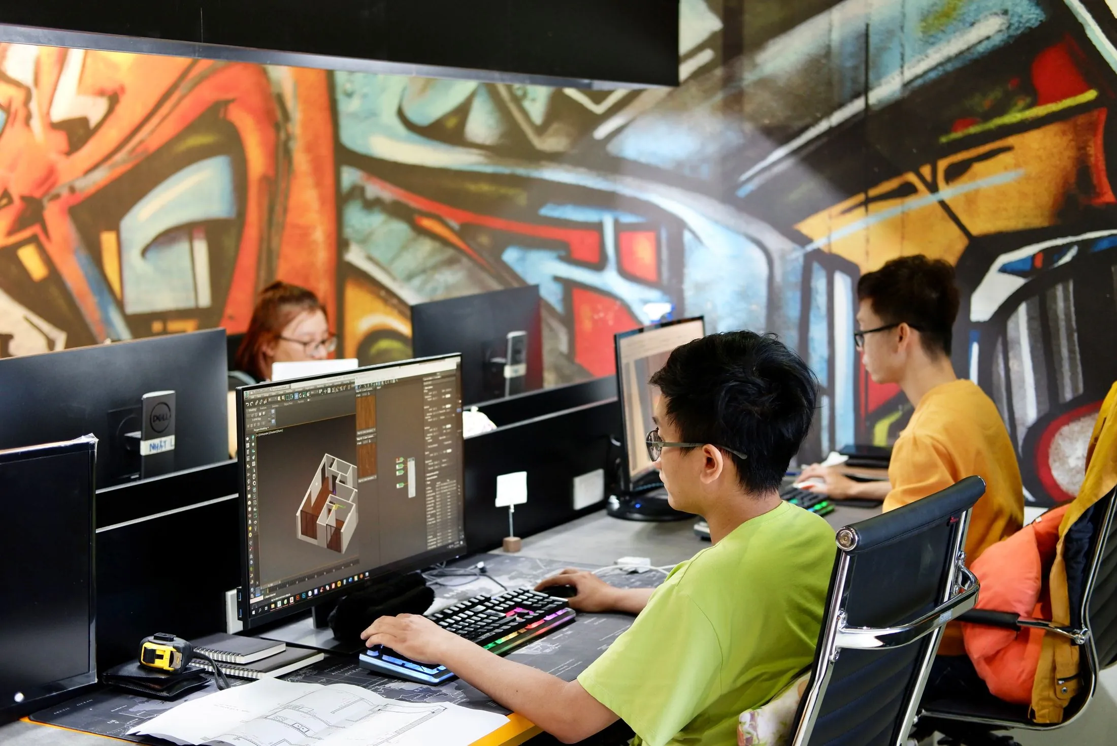 A team working at computers in a studio with graffiti-covered walls