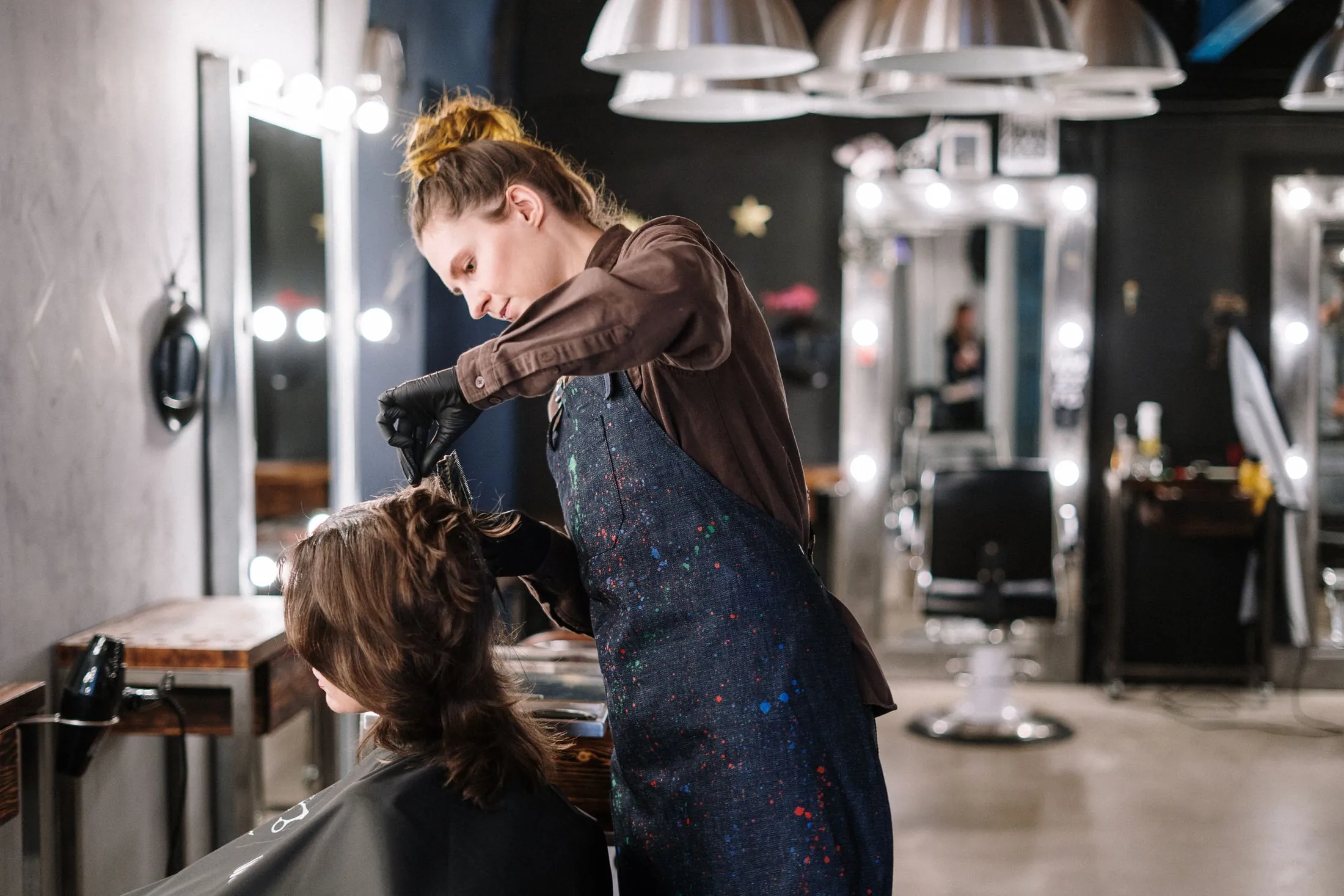A stylist working on a client's hair at the basin