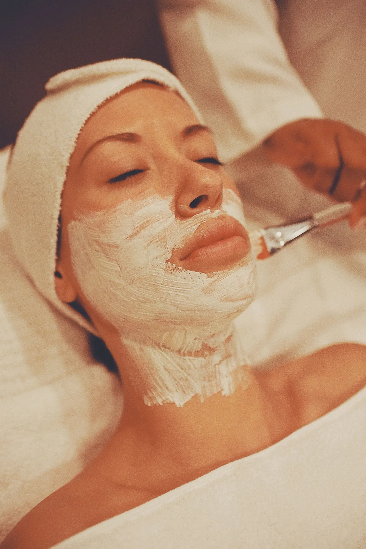 A client relaxing during a facial treatment at a spa