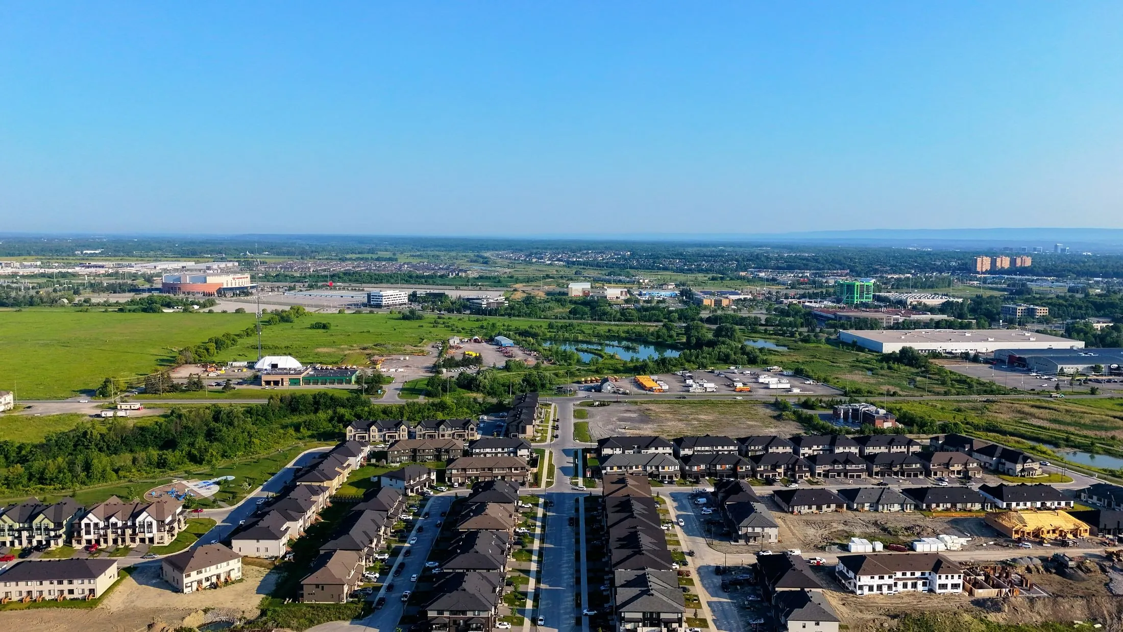 An aerial view of new homes going up beside open farmland