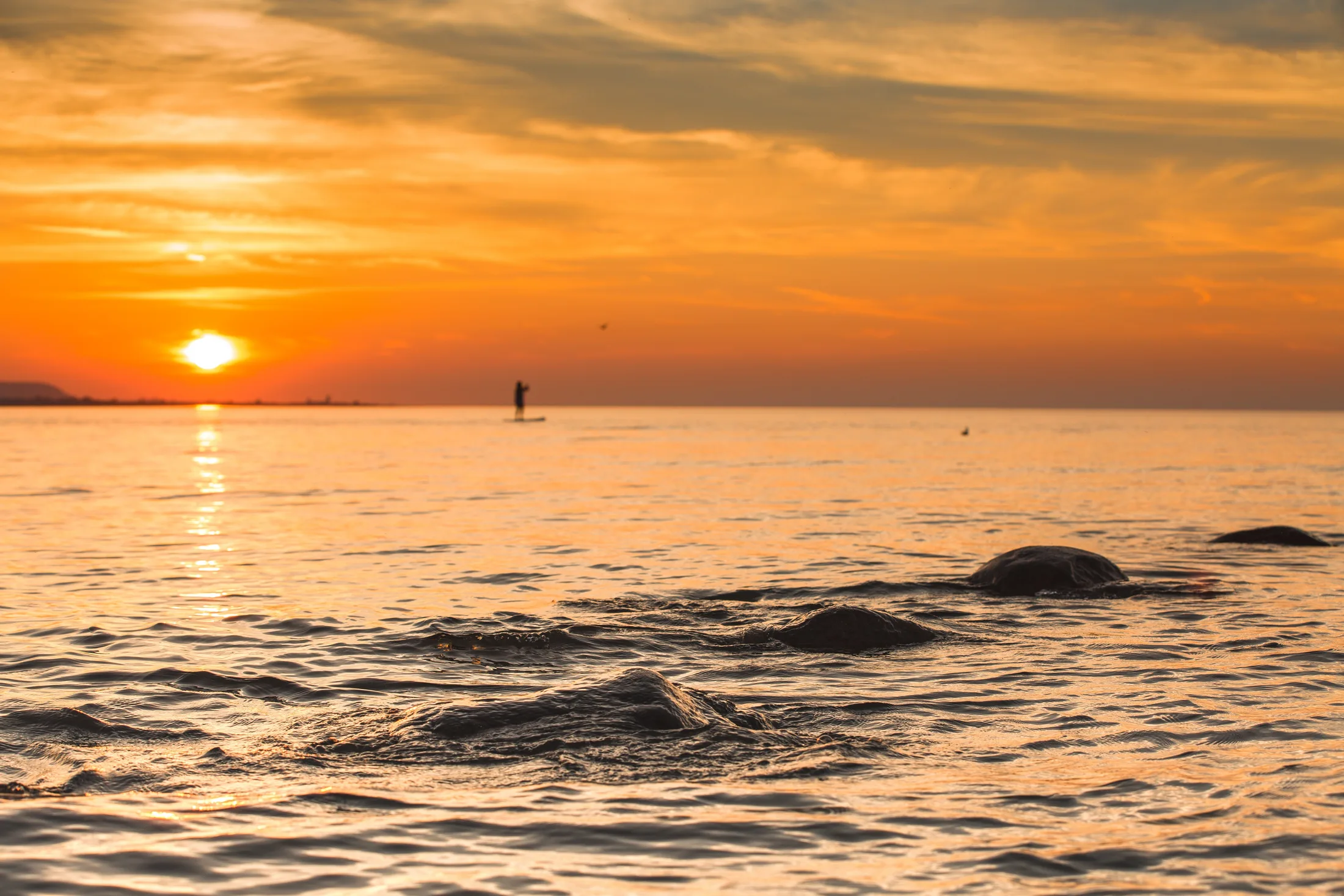 Sunrise over Georgian Bay with a paddleboarder on the water