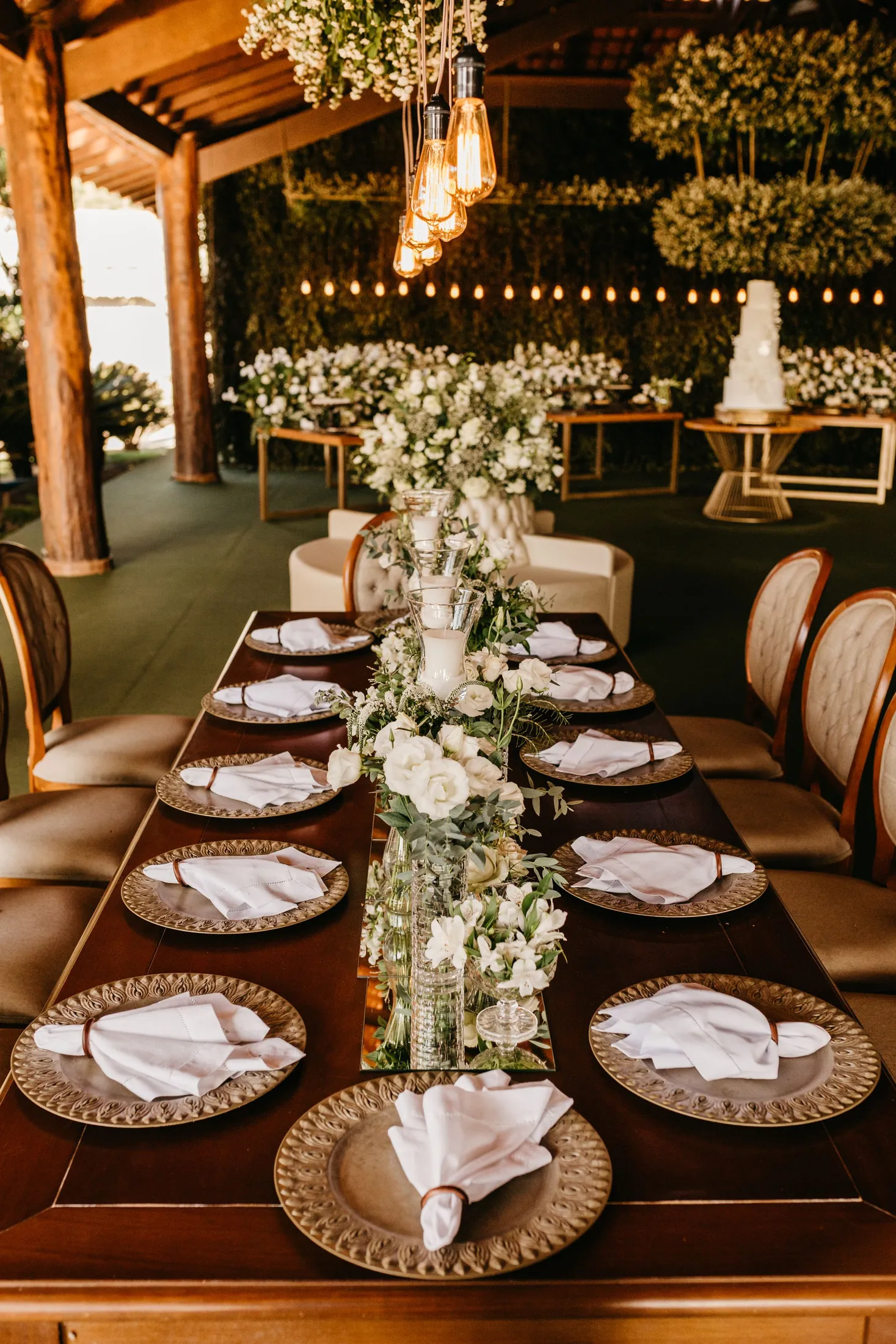 A long wedding table set with flowers and warm lights